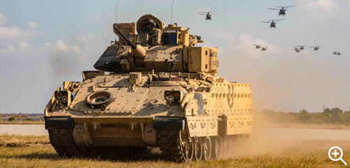 An Army Bradley fighting vehicle moves into position as UH-60 Black Hawks conduct a flyover during an air assault demonstration at Mihail Kogalniceanu, Romania, July 30, 2022. - ALLOW IMAGES