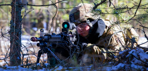 Army Pfc. Andrej Roberts, an 11 Bravo infantryman assigned to the 2nd Cavalry Regiment, posts security with an M249 squad automatic rifle in Adazi, Latvia, March 9, 2022. The 2nd Cavalry Regiment, also known as the 2nd Dragoons, is in Latvia supporting the multinational exercise Saber Strike.  - ALLOW IMAGES