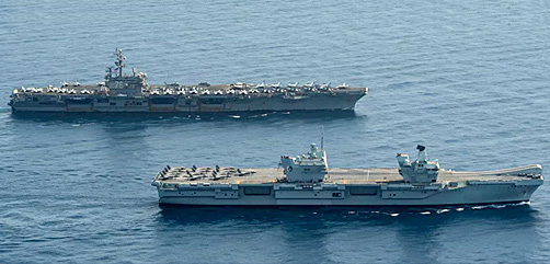 Royal Navy aircraft carrier HMS Queen Elizabeth (R 08), front, and aircraft carrier USS Ronald Reagan (CVN 76) operate in formation in the Gulf of Aden, July 12. - ALLOW IMAGES