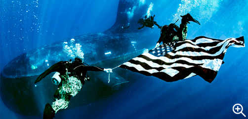 Sailors assigned to Naval Special Warfare Group 8 display the flag while performing dive operations from the fast attack submarine USS New Mexico in the Atlantic Ocean, June 19, 2022.- ALLOW IMAGES