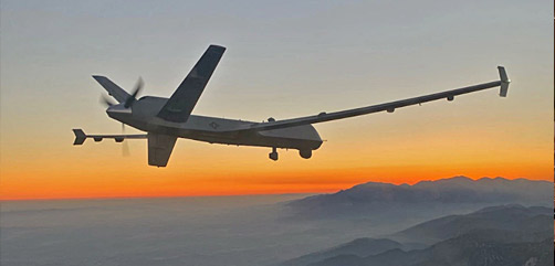 An MQ-9 Reaper remotely piloted aircraft flies above the smoky San Gabriel Mountains of southern California on its way to a fire mission in the northern part of the state.- ALLOW IMAGES
